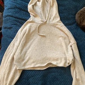 Stickad tunn hoodie - Jag säljer min stickade hoodie från monki, den är som en magtröja så den e fin med ett linne under, den e ganska tunn också och har lite vidare armar 