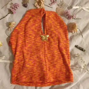 Ett orange rött linne som är halterneck från gina tricot i storlek s.