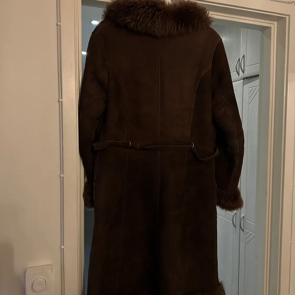 Superfin lång kappa i mocka med innerfoder av fuskpäls. Står ingen storlek men skulle uppskatta den till en L/ XL. Funkar på en M om man vill ha den oversize! . Jackor.