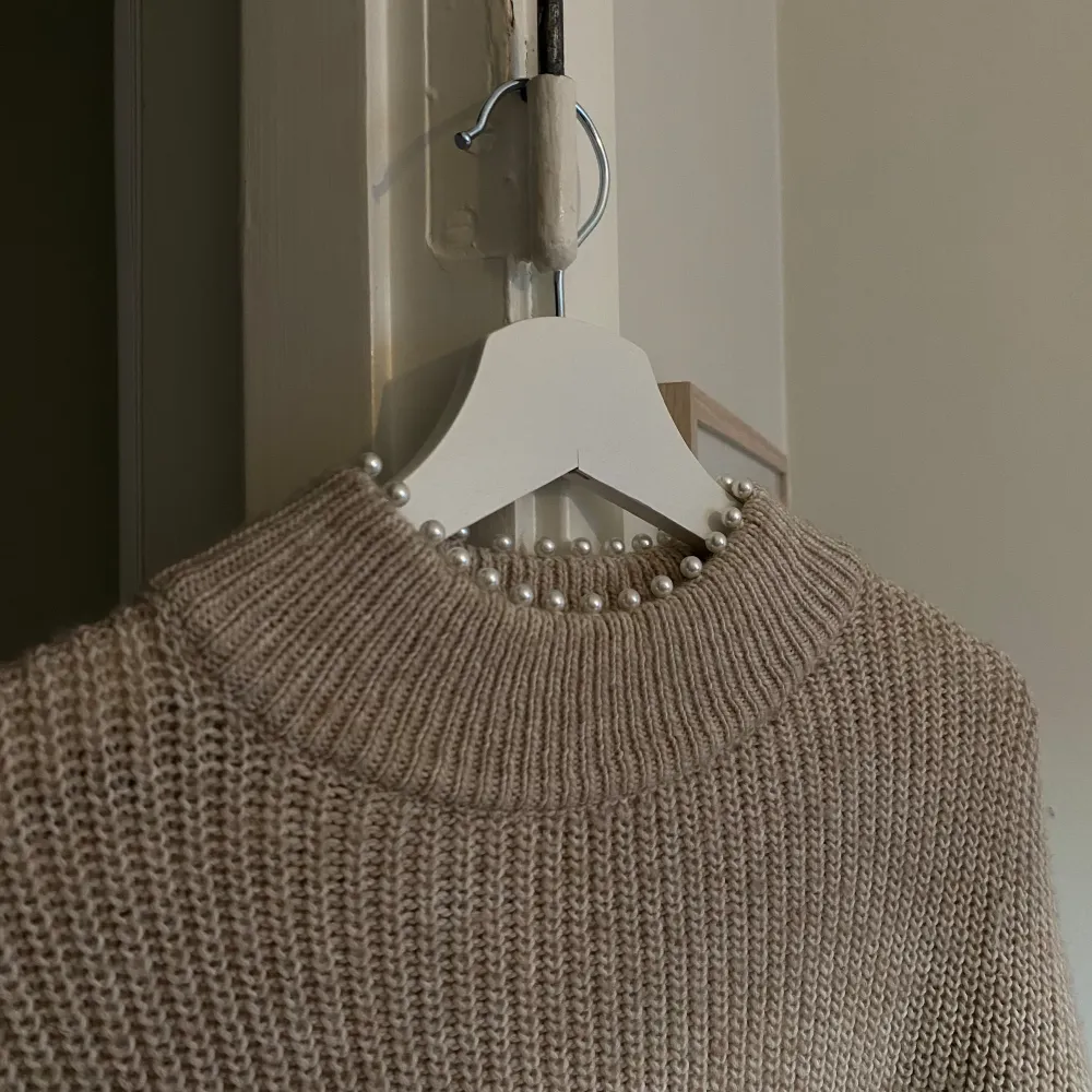 Stickad tröja med pärldetalj på kragen.  Några år gammal, från H&M, lite nopprig syns på närbilderna. . Tröjor & Koftor.