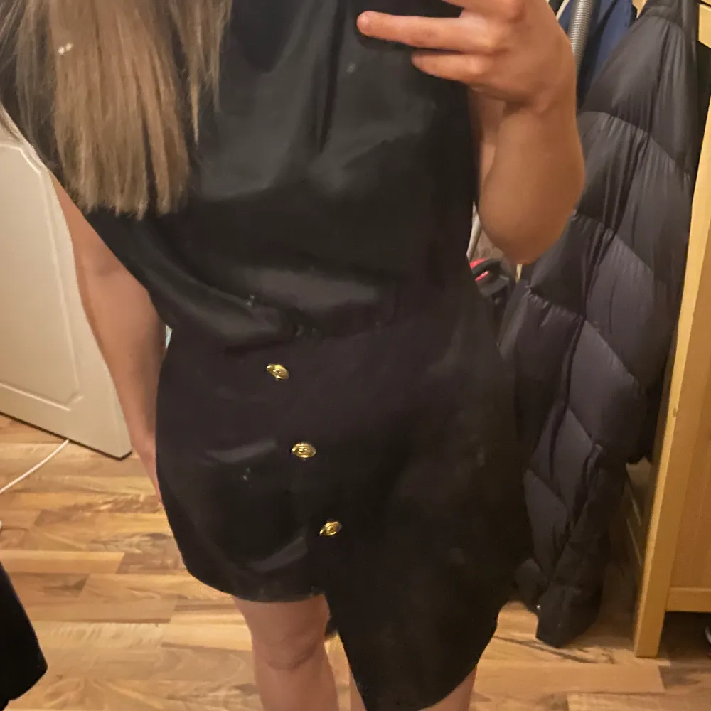 En så fin svart jumpsuit med guldknappar i nyskick💕ser ut som en klänning framifrån. Toppar.