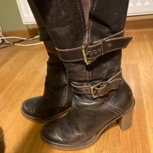 höga klackar med spännen - bruna klacka som går högt pp smalbenen med spännen