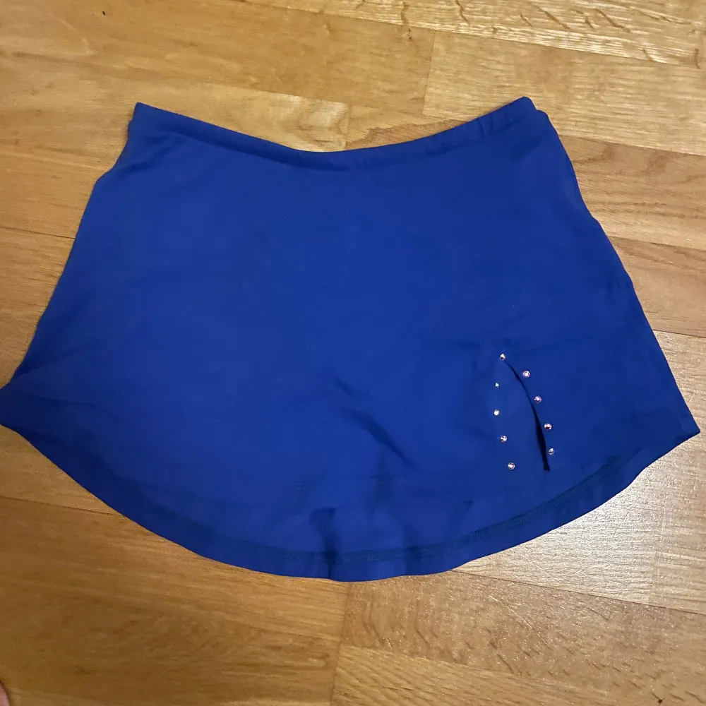 Marinblå kjol från bolero med detaljer. Har innerbyxa ifall den åker upp. Endast använd få gånger och är helt utan defekter! Nypris ca 650kr. Kjolar.