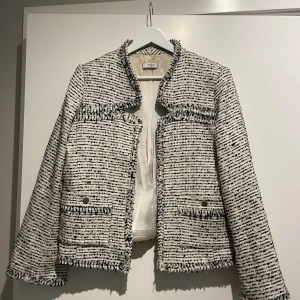 Kavaj/Jacka - En fin kavaj/Jacka från Mango, i storlek L. Vit, svart med en silver glittrig tråd i.