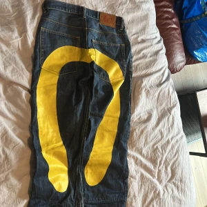 Evisu Jeans - Mörkblåa Eviesu jeans. Bra skick enda defekt är att dom är lite slitna i botten av dem. Storlek 29/34 men uppsydda några cm så skriv om ni har några funderingar om storleken så kan jag mäta. Priset är inte fast 