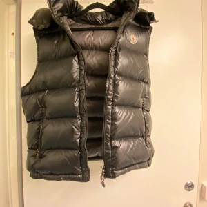 Svart dunväst från Moncler - Hejsan jag vill sälja min Moncler väst för den passa ej min still längre jag kan beskriva västen lite den är riktigt  skön och bra för sommar kväll. Jag kan fixa mer bilder och prist kan sänkas för en snabb affär hoppa vi hörs 🤙 
