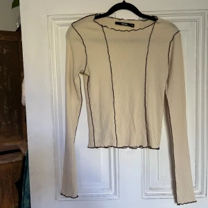 långärmad tröja  - Långärmad tröja från bikbok. Den är beige med bruna sömar på utsidan och kommer passa perfekt till hösten nu! Den är xs men passar även mig som är s