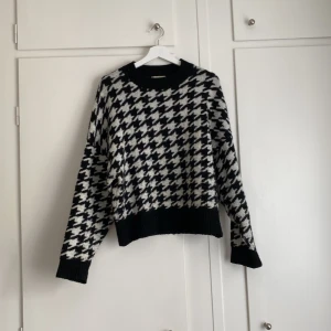 Stickad tröja hundtandsmönstrad  - Snygg stickad tröja i hundtandsmönster. Varm och bra att ha på sommar kvällar eller under vintern. Beroende på hur stor man vill ha den passar den XS-M lätt. Jag är M och bär den men den är storlek XS från grunden.