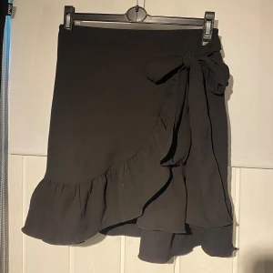 Omlottkjol - Svart omlottkjol med knytning i midjan, endast använd en gång därav nyskick. Köpt på Vero Moda för 299kr