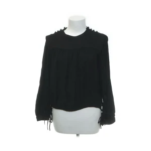 Svart långärmad topp från Isabel Marant Étoile - En elegant svart långärmad topp från Isabel Marant Étoile. Toppen har dekorativa knytningar vid ärmsluten och en rund halsringning.💕
