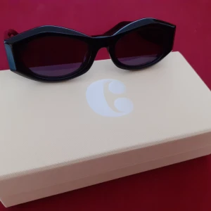 Corlin Solglasögon - Solglasögonen är en oversized och distinkt cat-eye modell. Fodral i konstläder och kartong medföljer Handgjord i bio-acetat, reptålig CR39-lins, 100% UV400 skydd. Linshöjd: 35mm, linsbredd: 55mm, näsbrygga: 20mm, skalm: 145mm. Helt nya och oanvända, 