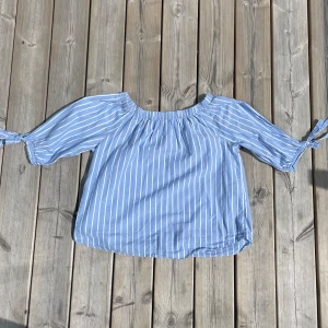 Blå vit sommartopp - Superfin och somrig sommartopp med söta rosetter vid armarna. Ifrån H&M och är storlek xs/s. Aldrig använd och är i super bra skick💗