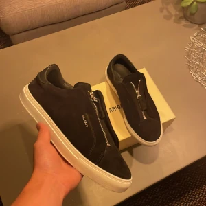 Arigato clean 90 zip - Säljer ett par axel arigato clean 90 zip med svart mocha och vit sula. Skick 9/10. Box och dustbag tillkommer. Storlek 43. Hör av dig vid funderingar 💯