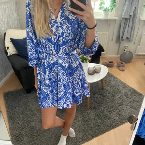 Blåvit klänning  - En jättefin blåvit mönstrad klänning från pigalle (only). Använd fåtal gånger så i bra skick. Bandet går att välja om man vill ha på sig eller inte🩷
