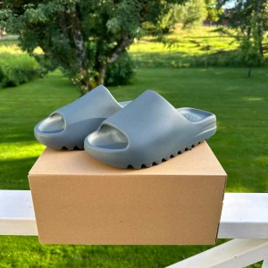Yeezy Slide Slate Marine - Säljer ett par Yeezy Slide Slate Marine i storlek 42. Helt nya aldrig använda och original boxen finns kvar. Hör av dig för mer info eller frågor! Kan gå ner lite i pris vid en snabb och smidig affär