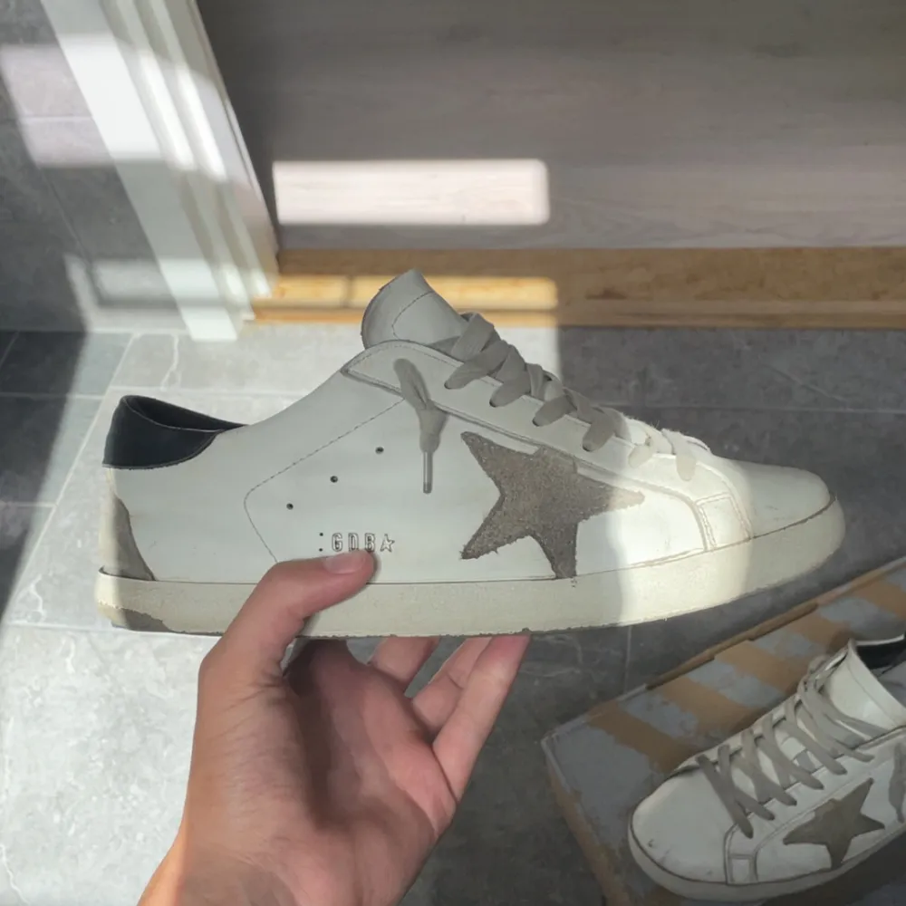 Ett par vita Golden Goose Super-Star sneaker. Använda sällan och några slitage ingenting man märker.  Kom privat vid några funderingar😎🌟  Skorna ser höga ut pga crease skydd. Skor.