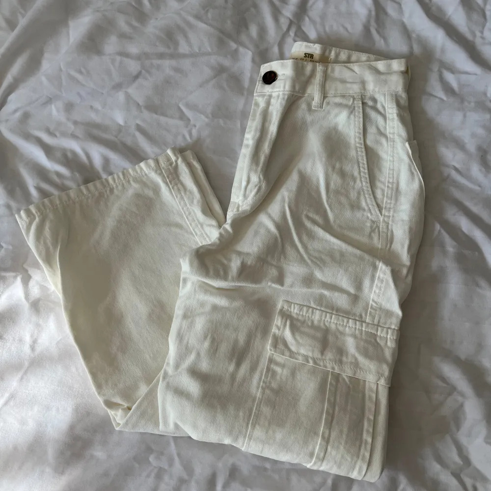 Cargobyxor vita från Zalando/Stradivarius i storlek 34. Vita, fickor fram och bak + 2 på varje ben.  Oanvända, nypris 359 kr . Jeans & Byxor.