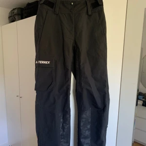 Adidas Skidbyxor - Svarta snygga skidbyxor (skal) från adidas! Använda men inga tydliga tecken på användning. Nypris 3 899 kr.