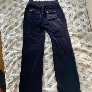 Juicy couture byxor - Mörkblåa juicy couture byxor i storlek xs, relativt använda, en utav snörenas metallgrej har lossnat men man får med det så man själv eventuellt kan laga det, skriv privat för fler bilder❤️