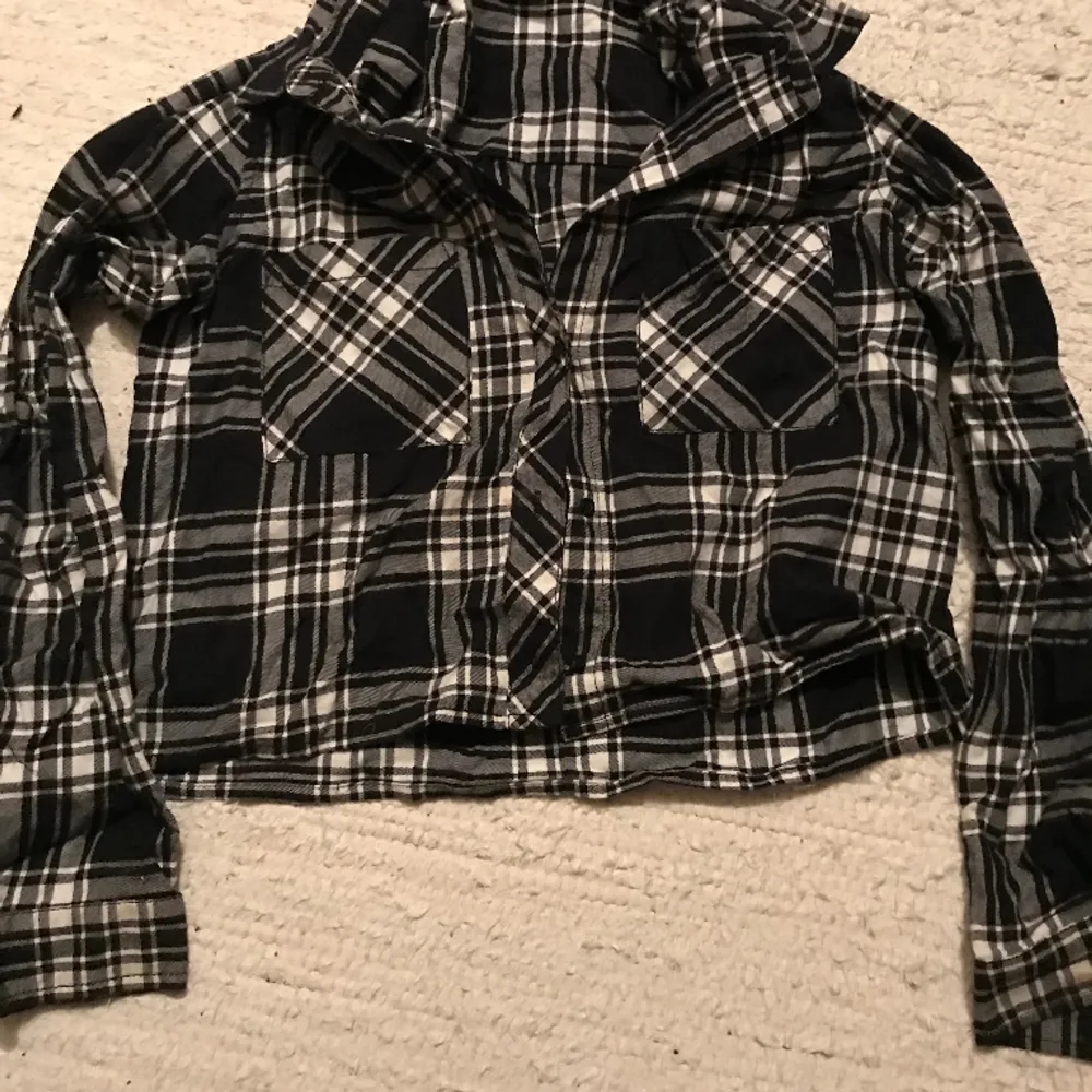 Rutig croppad tröja med knappar. Det är en knapp i slutet av ärmen(bild 2). Två st fickor på brösten❤️❤️. Skjortor.