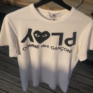 Commes des garcon tshirt - En vit t-shirt med text. Köptes för 950kr på NK har använt den sällan men tagit hand om den. Den är 8.5/10 i skick.  Strlk S men passar även XS