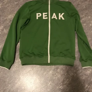 Peak performance vintage - En grön snygg zip up Hoodie för killar o tjejer spelar ingen roll strl L. Har använt den bara på somaren då och då. Har inte sett än ända sån hoodie på någon annan förr så ganska sällsynta.  Om du har någon fråga är det bara att skriva😁 