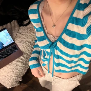 Tröja med knytdetalj! - Blå och vit randig långärmad tröja med snörning där fram! Köpt i London förra året!