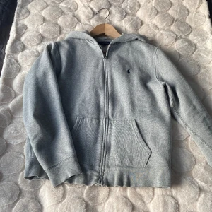 Ralph Lauren Zip Hoodie - Säljer denna gråa Polo Ralph Lauren Zip Hoodien som är i storlek XL i barnstorlek men det motsvarar ungefär S. Den passar bra på mig som är 173. OBS Pris kan diskuteras vid snabb affär. Kom privat för mer info