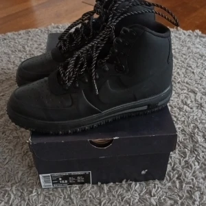 Nike Lunar Force 1 - NIKE – unisex  Svarta vattentäta skor med reflekterande skosnören. Skorna är bra uppbyggda och är en tåligare modell av Air Force 1. Funktion och mode i bra kombination!  Storlek 42.5 (US 9 men och US 10.5 woman) - Modell Unisex.  Nypris 1950 kr