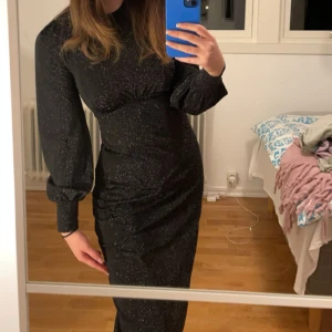 Glittrig klänning  - En svart glittrig klänning från bubbelroom. Använt två gånger så den är som nyskick. Passar till fest/ nyår eller glittrigt tema. Den är sydd under brösten som ger ett fint lyft och att ens former syns. Jag brukar ha S i kläder men den passar mig ändå. 