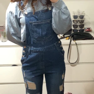 Hängselbyxor  - Ett par hängselbyxor i jeans i ny skick 