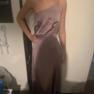 Balklänning  - Balklänning från Nelly som aldrig är använd och prislappar finns kvar. Rosa/lila färg