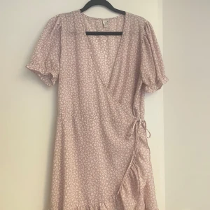 Rosa blommig klännimg - Kort rosa klänning med vita blommor.  Storlek 38. 