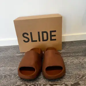 Säljer ett par extremt sköna yeezy slides storlek 42 i färgen Flax då de tyvärr har blivit försmå. Defekterna ser ni på bild nr 3 och 4.  Men dem är fortfarande lika sköna som när dem var nya. Priset är inte huggget i Sten vid snabb affär.