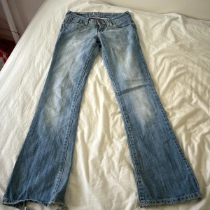Ljusa lågmidjade bootcut jeans - Så sjukt snygga jeans. Lite nedtrampade där bak där nere som man ser på bilden Midjemåttet 37cm rakt över men inte så stretchiga i midjan, innerben: 80cm, grenhöjd:18cm. Använd gärna köp nu