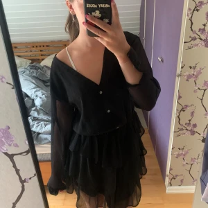 Långärmad svart klänning  - Säljer denna jättefina klänningen från Gina, den är lite genomskinlig på ärmarna och går att knäppa de längst ut. Säljer pga lite stor på mig så tror klänningen passar som M också💕. Den är helt oanvänd, bara testad och tror originalpriset va 300-400.