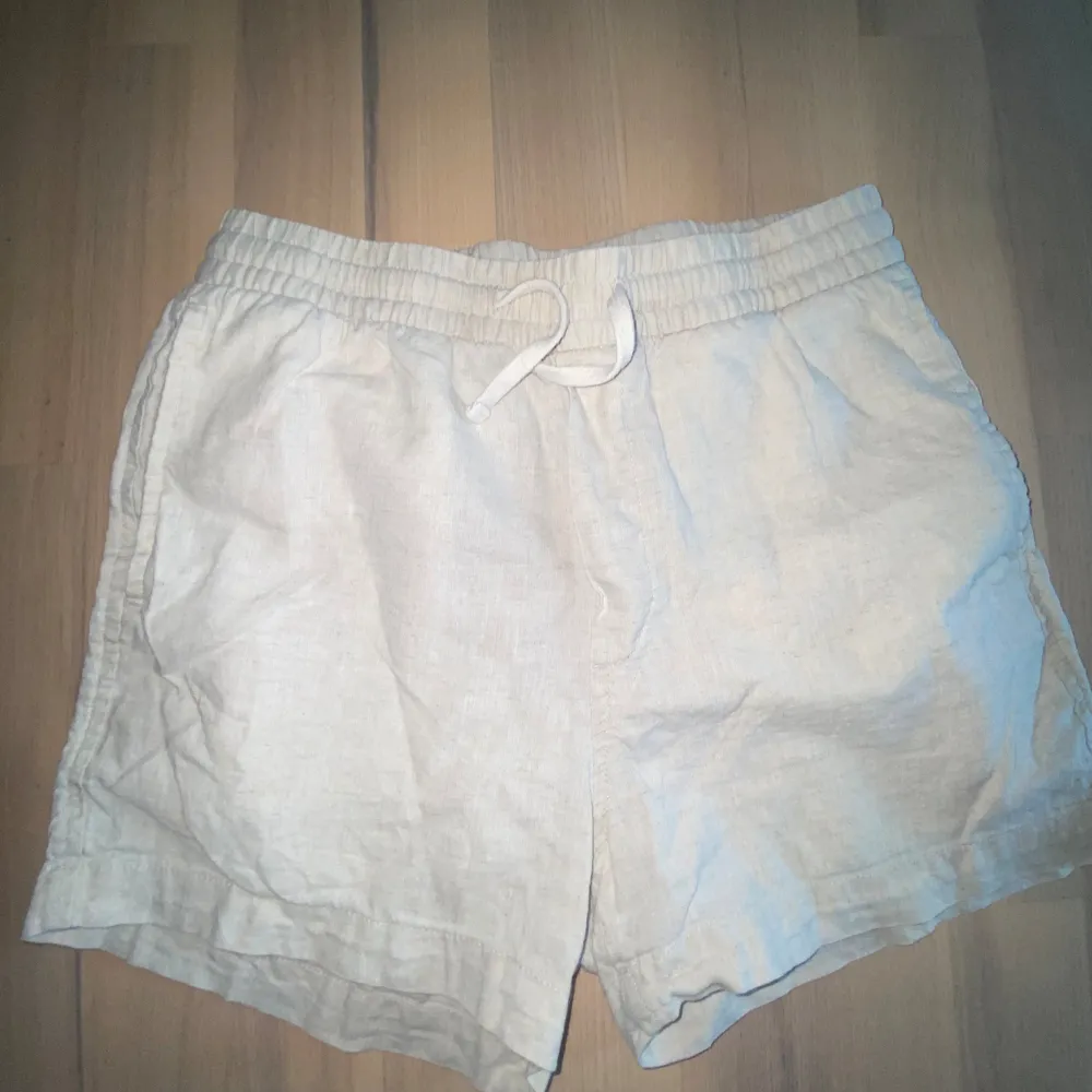 Säljer ett par bekväma linne shorts med snörning i midjan. De är perfekta för sommaren och har en avslappnad passform. De passar perfekt till varma dagar. De har en elastisk midja och en bakficka. Väldigt fina men är för små för mig. . Shorts.