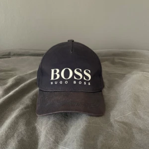 Hugo Boss keps - En Hugo Boss keps som är använd ett fåtal gånger. Den är i väldigt bra skick. Pris kan diskuteras vid snabb affär!