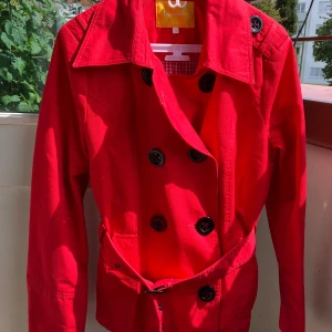 Röd trenchcoat, sunshine, stl 38 - Röd kort trenchcoat, svarta knappar fram, skärp, stl 38, bomull