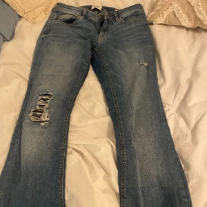 Bootcut lågmidjade jeans! - Intressekol på mina super snygga jeans med revor. Lågmidjade och bootcut! De är storlek 28/32. Har inga fler bilder 💕