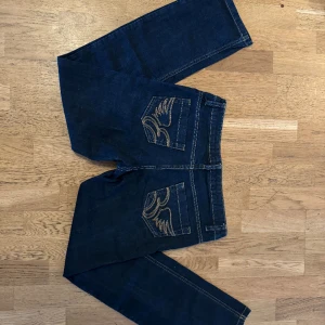 Jeans med coola detaljer - Coola jeans i snygg passform! Jeansen är lågmidjade och sitter bra på kroppen samtidigt som dom är väldigt bekväma.   Midjemått: 80cm Innebenslängd: 80cm  