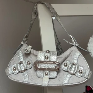 Väska - Så snygg Silvrig/grå gusacci väska. Den har flera fack på insidan och en tillhörande spegel. Kommer tyvärr inte till användning av mig. Vill du köpa trycker du på köp nu, jag postar inom 24h