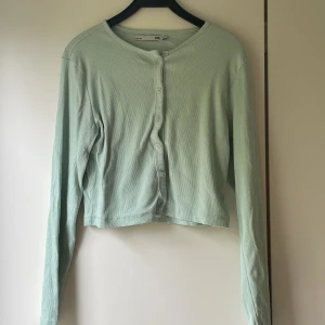 Turkos tröja. - En turkos tröja som funkar som en kofta. 