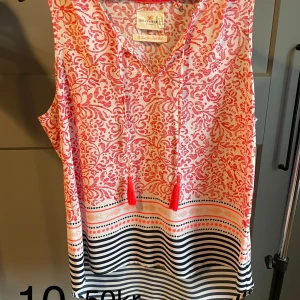 Flerfärgat linne - Flerfärgat linne med ”snören” med toffsar. Lös i modellen.