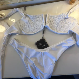 Bikini + coverup - Säljer denna super gulliga bikini från ZAFUL. Ettiketten är kvar och den är aldrig använd, strl M. Sen även en svart coverup från SHEIN, denna är i storlek L, även denna är helt oanvänd. Säljer dessa två ihop men kan även köpas separat! 