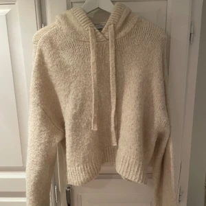 Stickad hoodie - Beige stickad hoodie från Zara. Perfekt att ha över en klänning på sommarkvällar🌅. Storlek M/L men passar på mig som brukar ha S. Skriv för fler frågor 💖