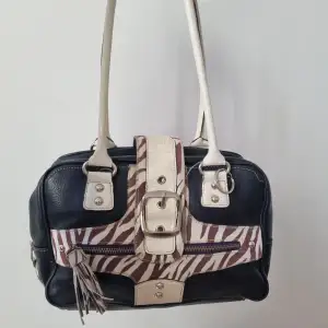 Svart handväska med zebra mönsteriga detaljer. Medel skick.