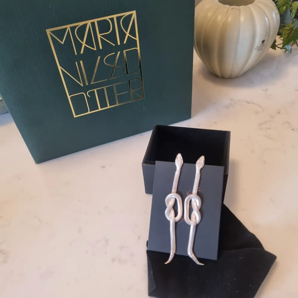 Ormörhängen i silver, ett par, från äldre Maria Nilsdotter kollektion. Köpte dem ca 2016 i butiken som då låg på Sturegatan i Stockholm. Precis haft dem inlämnade på rengöring och putsning i butiken.  . Accessoarer.