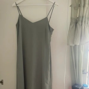 grå/silvrig midiklänning - grå/silvrig midiklänning från uniqlo i strl S, dock ganska stor i storleken. Aldrig använd