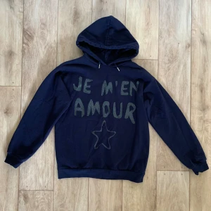 Blå marinblå mörkblå hoodie huvtröja luvtröja je m’en amour Gina Tricot Young stockholmstil - En marinblå hoodie med tryck på framsidan. Från Gina Tricot Young. Storlek 146/152! Fint skick.